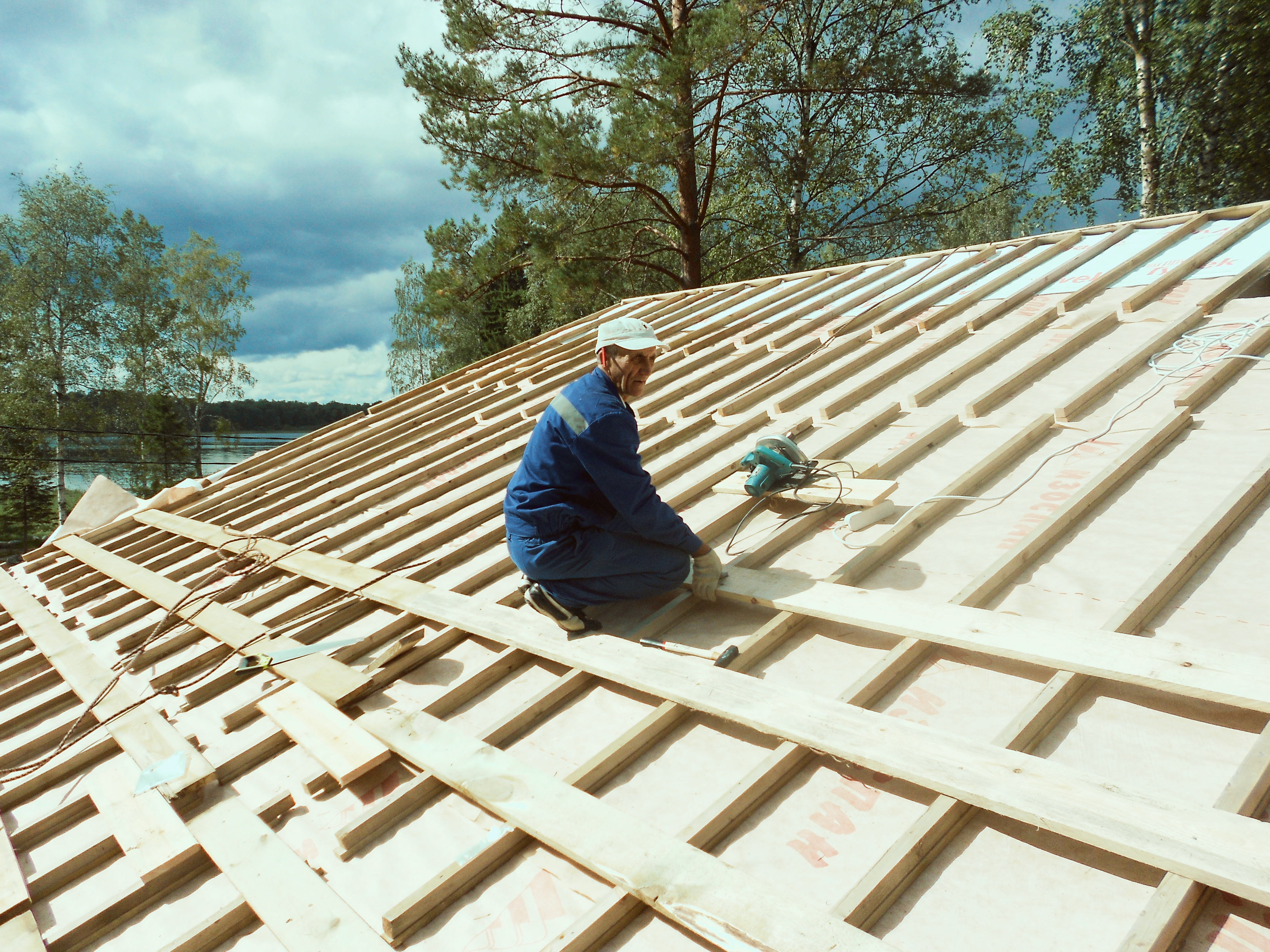 Technician repairing damaged roof shingles